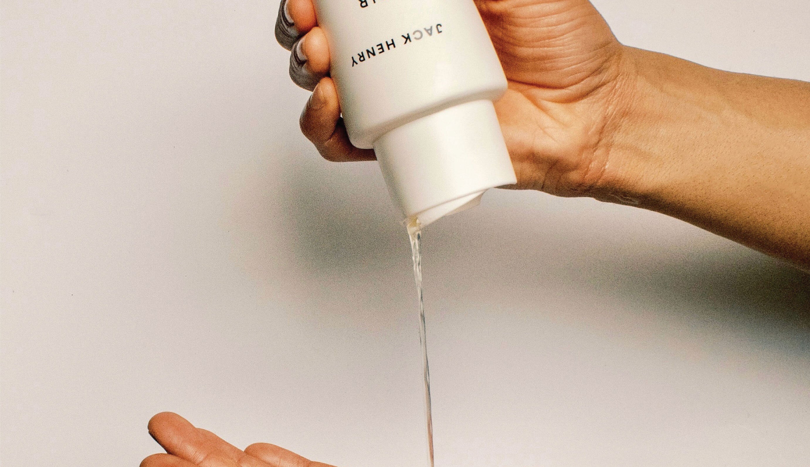Jack Henry Cleanse+ Shampoo being poured onto a hand, emphasizing its gentle lather and clean, nourishing formula.